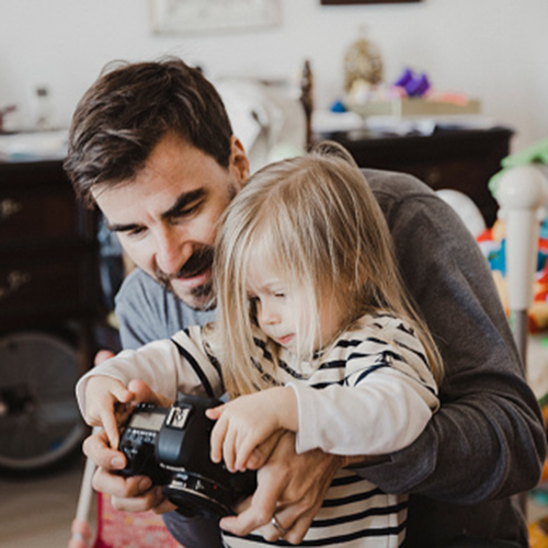 Father with daughter viewing images on back of camera