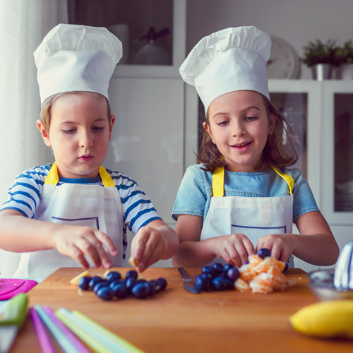 Kid chefs in the kitchen - preparing a healthy fruit snack