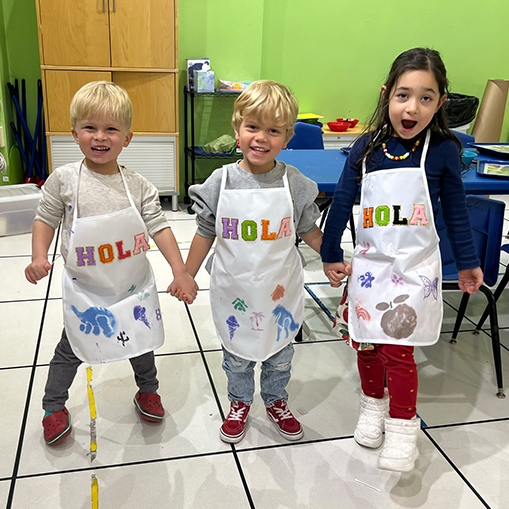 children wearing smocks that say