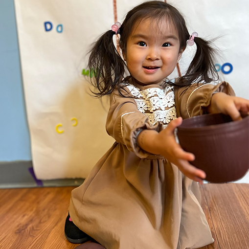 girl in pigtails holding a bowl