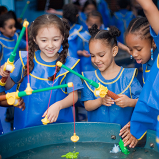 kids playing with pretend fishing rods and wearing smocks