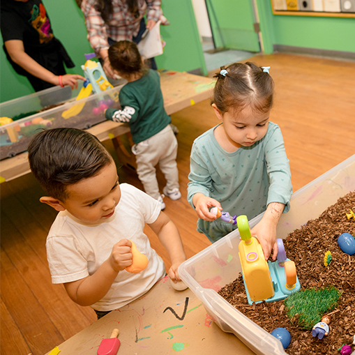 little boy and girl playing in sandbox