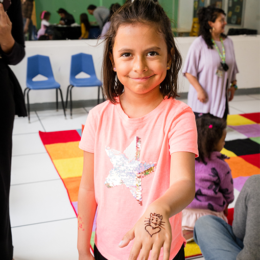 little girl showing off henna on hand