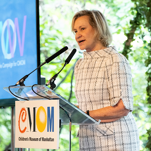 blonde woman speaking at a podium