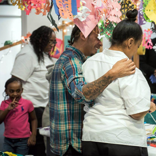 family standing with backs to camera getting ready to make art