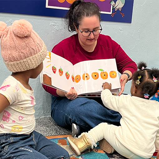 woman reading to two children