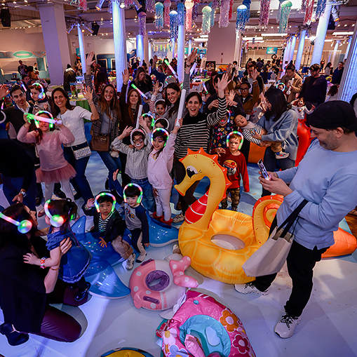 group of children sitting on floor with plastic floaties and glow sticks