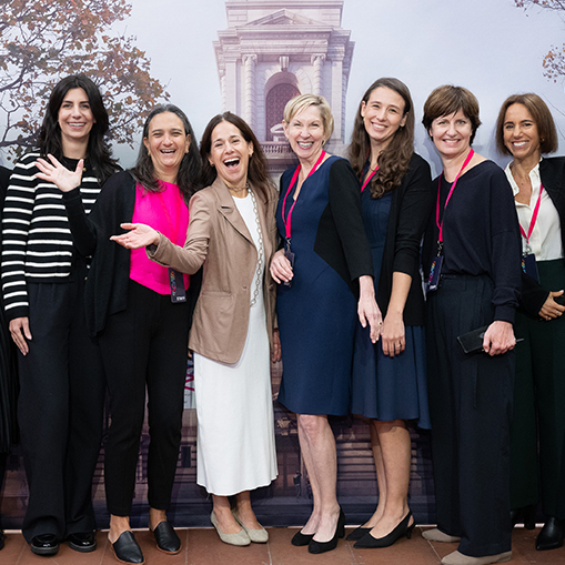 group of women smiling in front of a building background