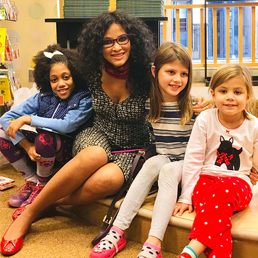 woman posing with three young girls at a bookstore