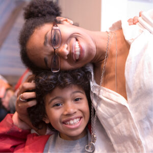 Mom and son hug and smile happily.