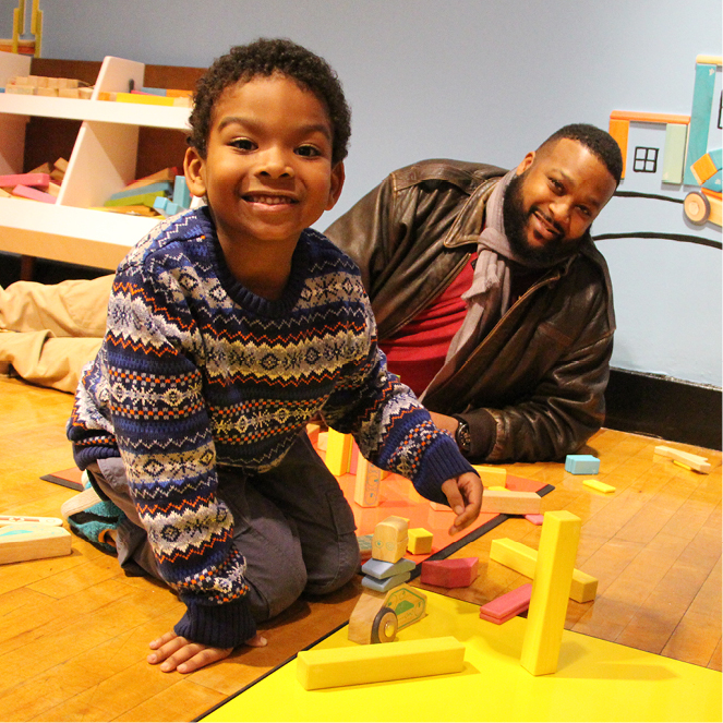A boy and his father build together.