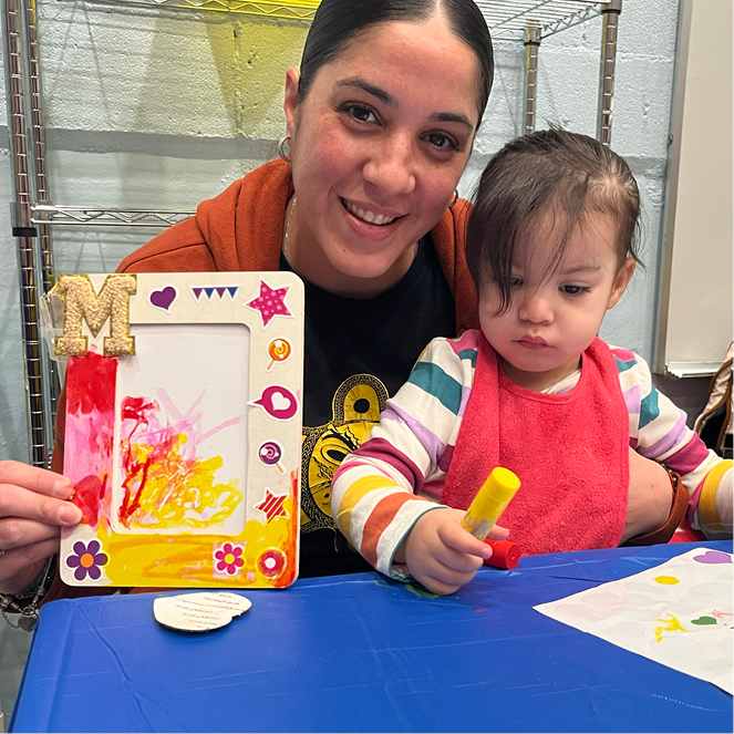 Mother and daugher work on a picture frame art project together.