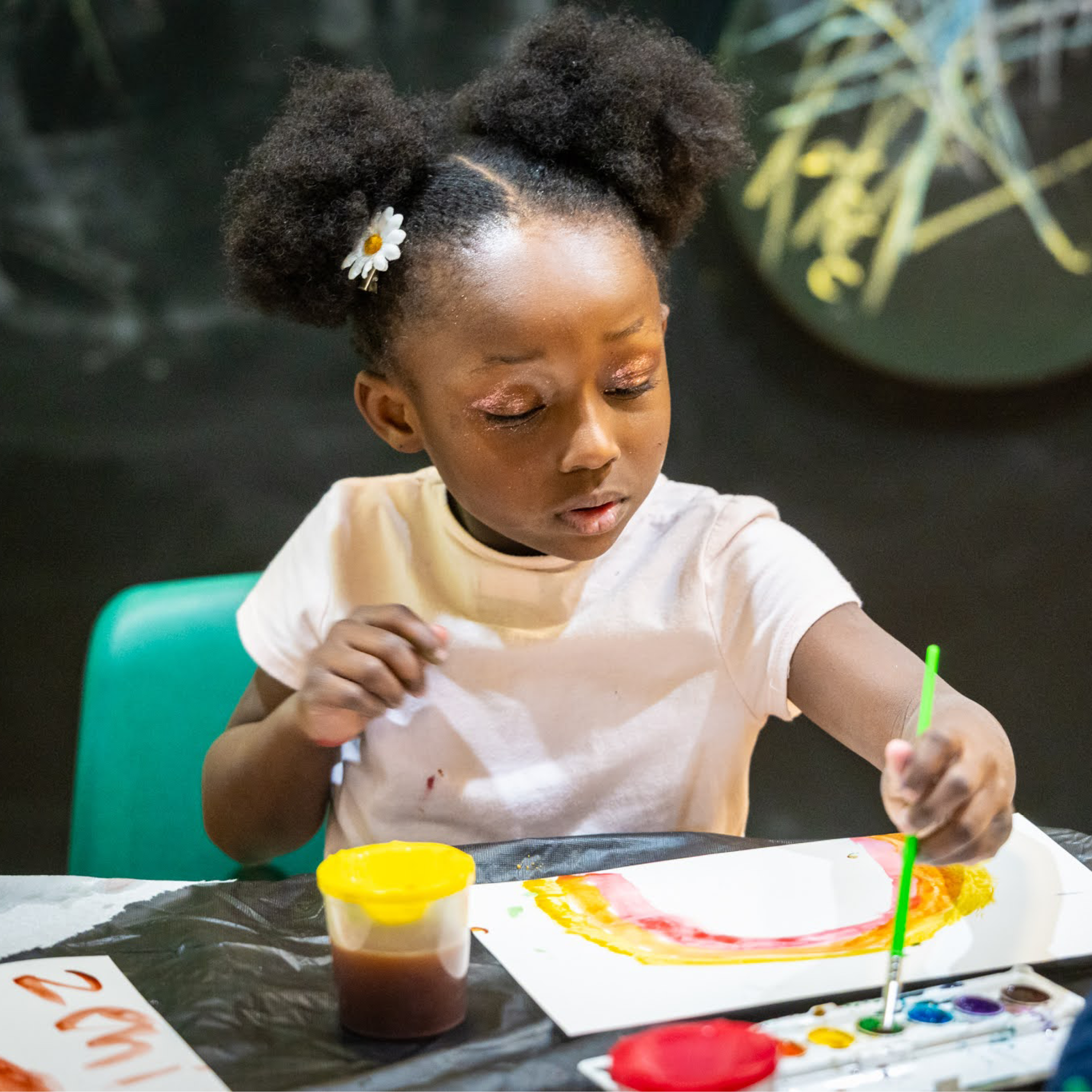A Child paints a rainbow with watercolor