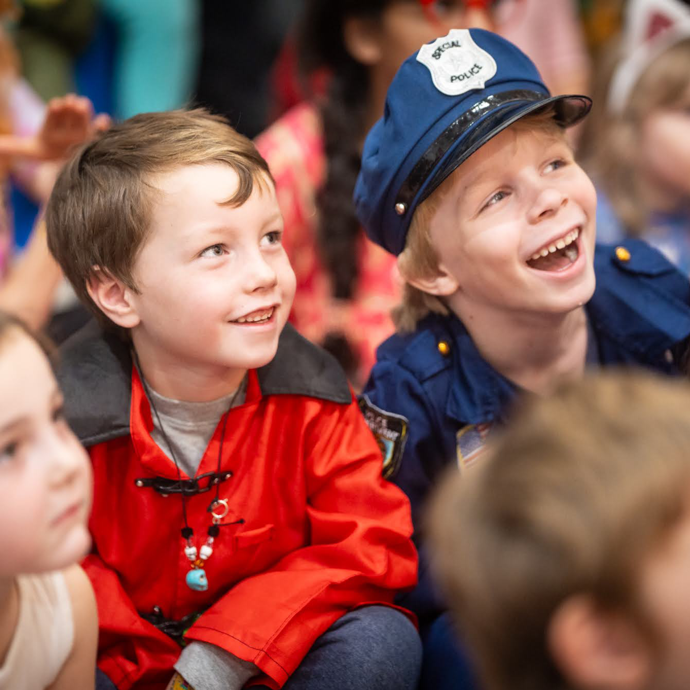 Kids laugh as they enjoy a performance.