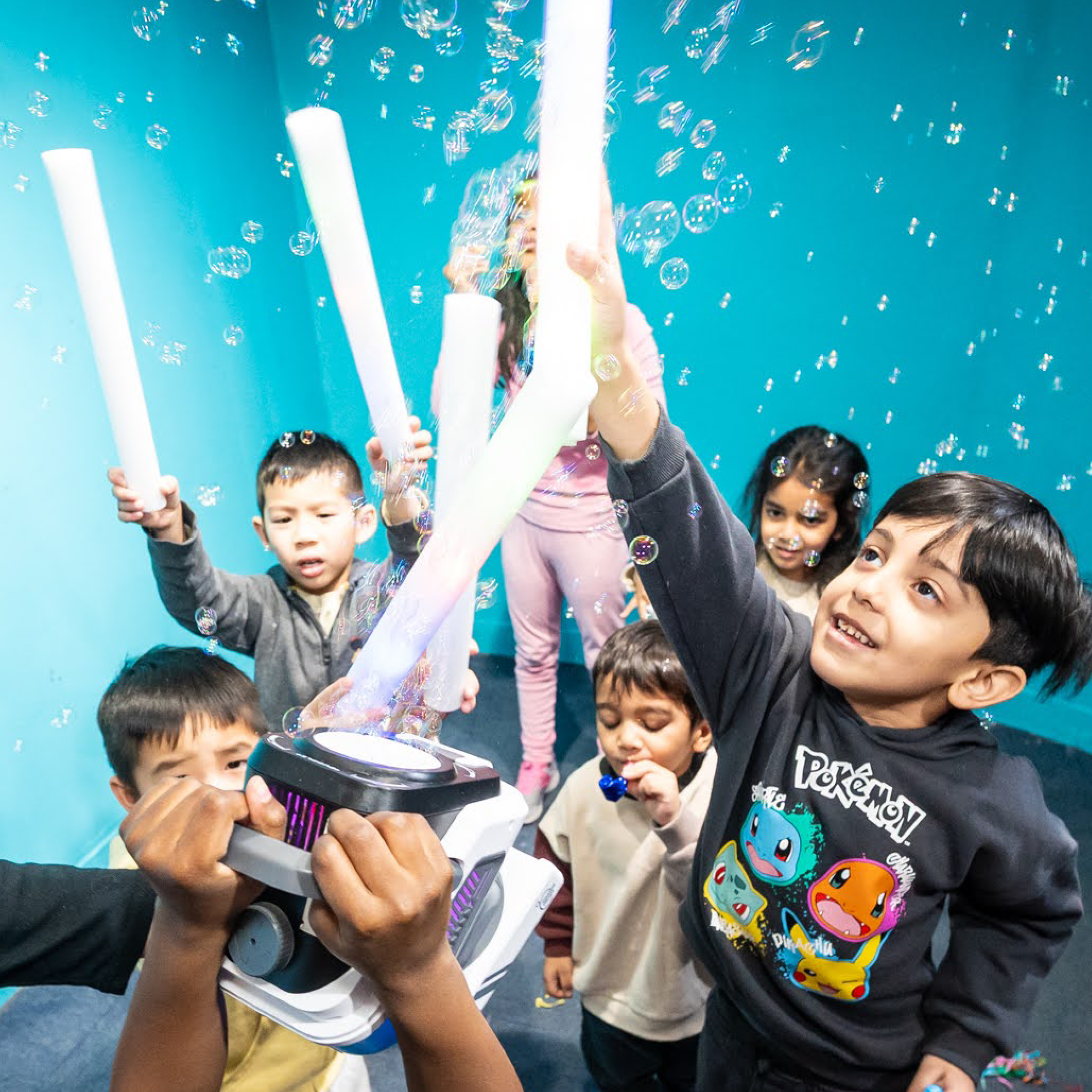 Kids dance with bubbles and glow sticks.