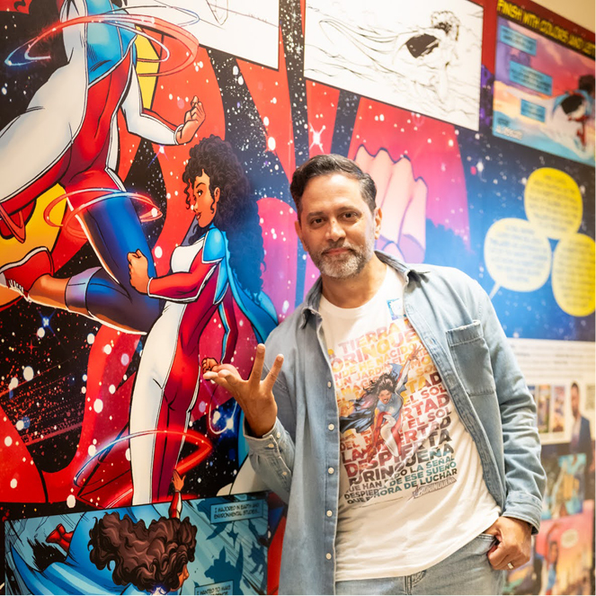 Artist Edgardo Miranda-Rodriguez’s stands next to his Superheroine La Borinqueña installation.
