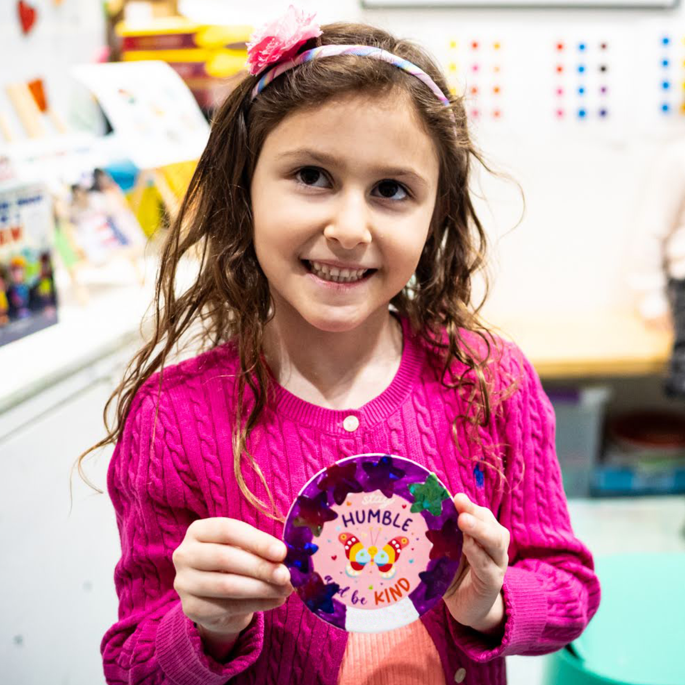 Girl holding up handmade badge
