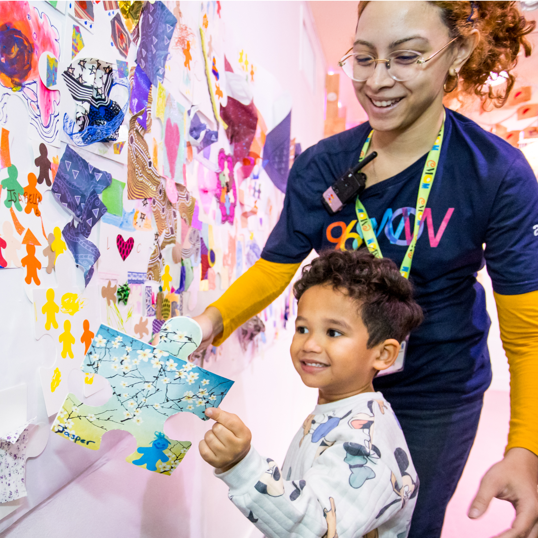 Child adds their artwork to a community mural.