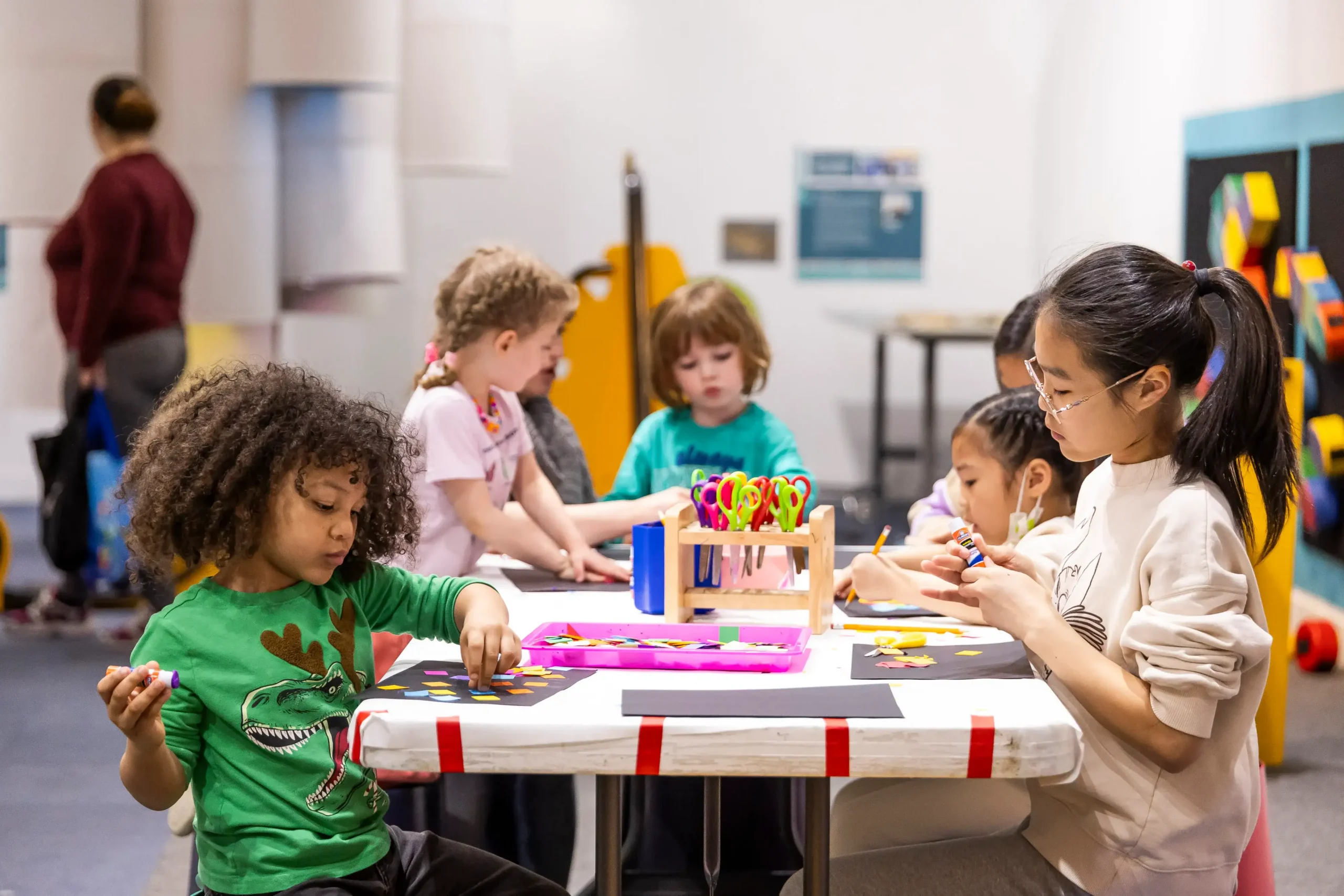 Five children are visible at a craft table while they work on crafts together