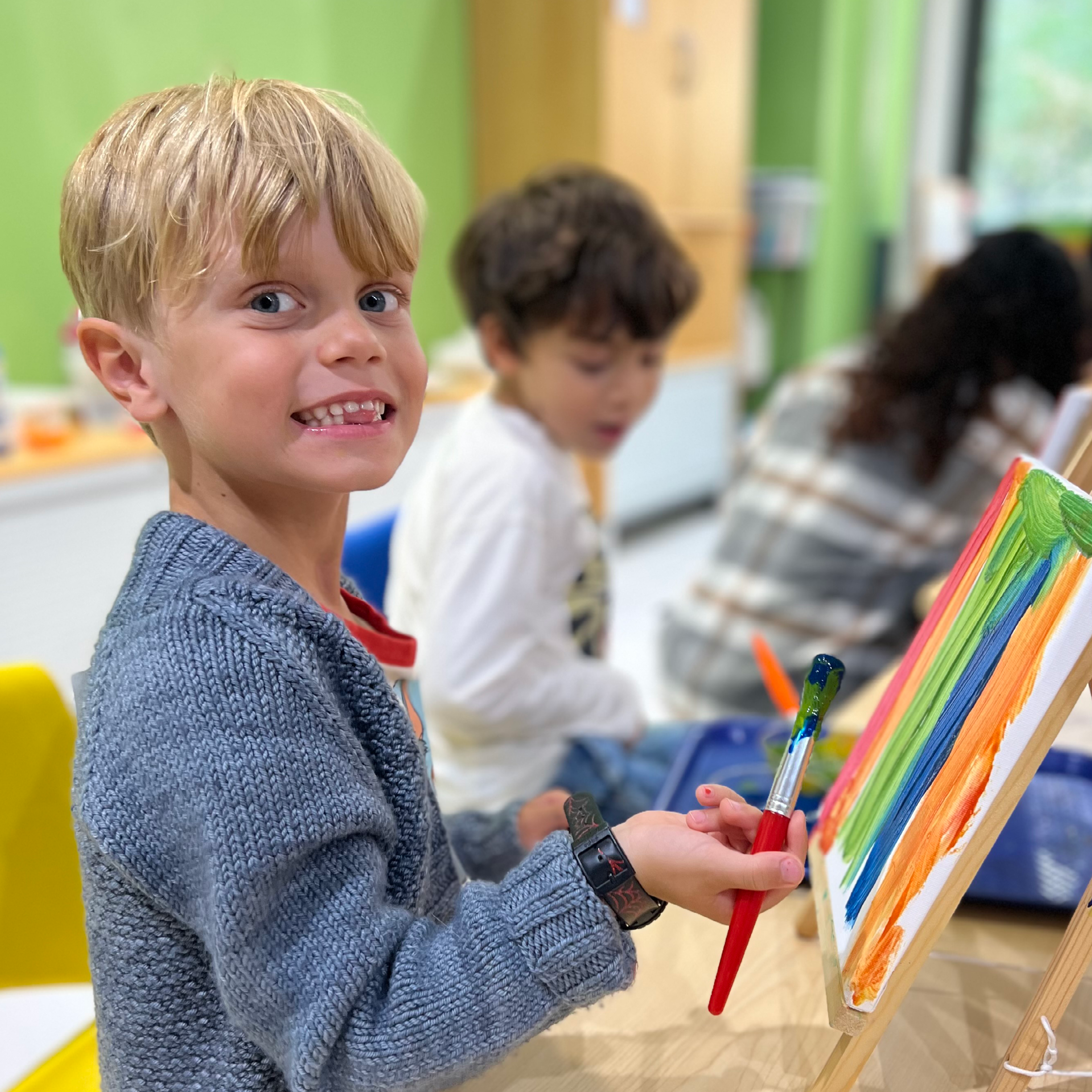 Kid paints at a tabletop easel.