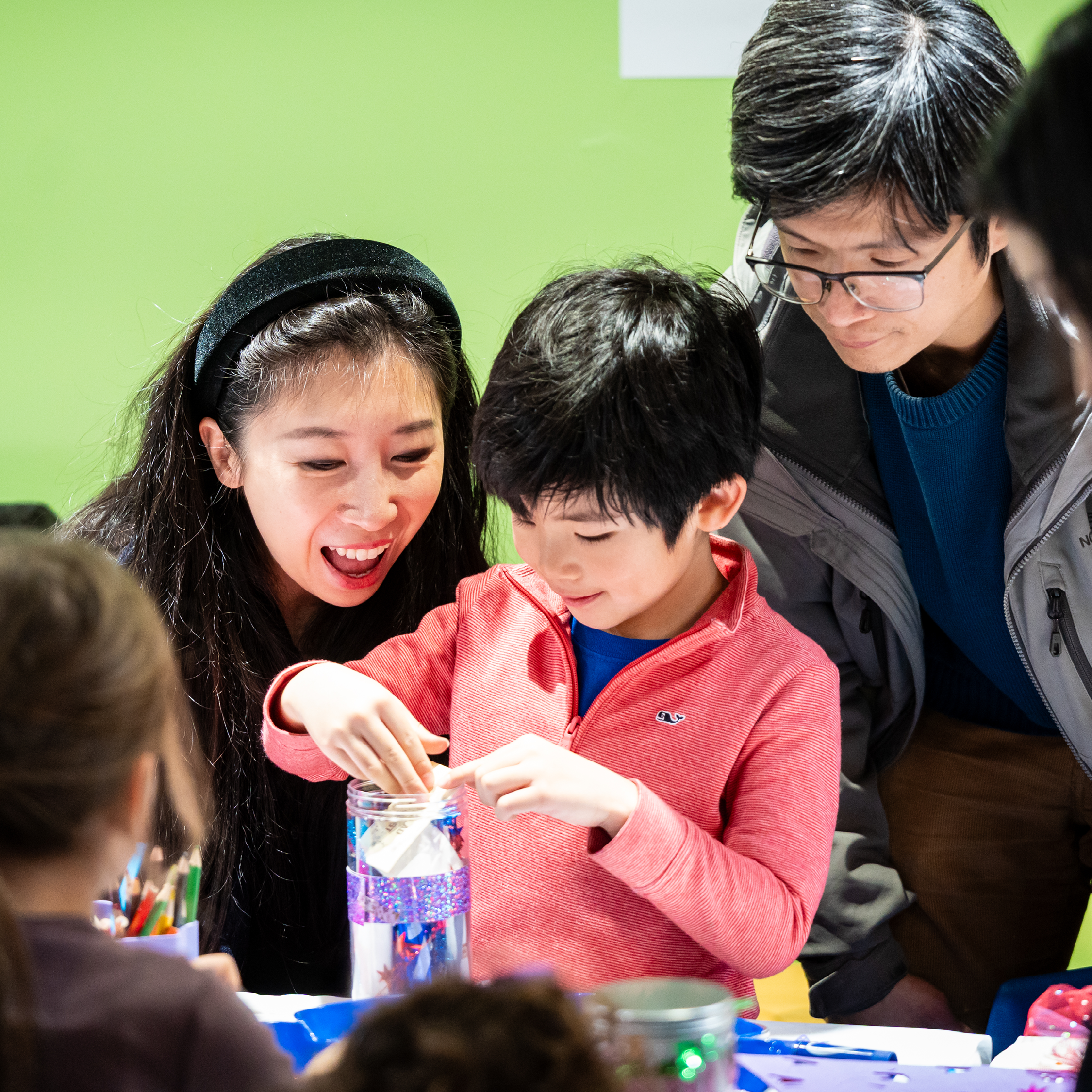 Child and caregivers work on an art project together.