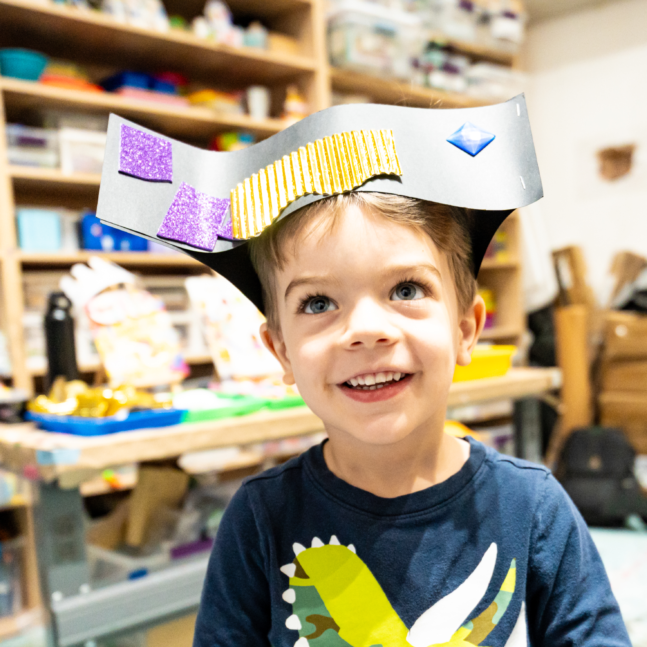 Child wears a black and gold hat they made