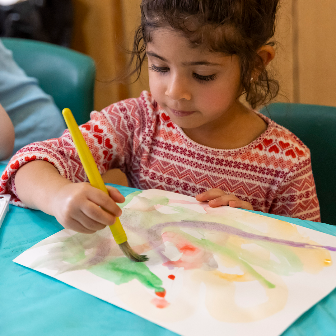 Child paints with watercolor
