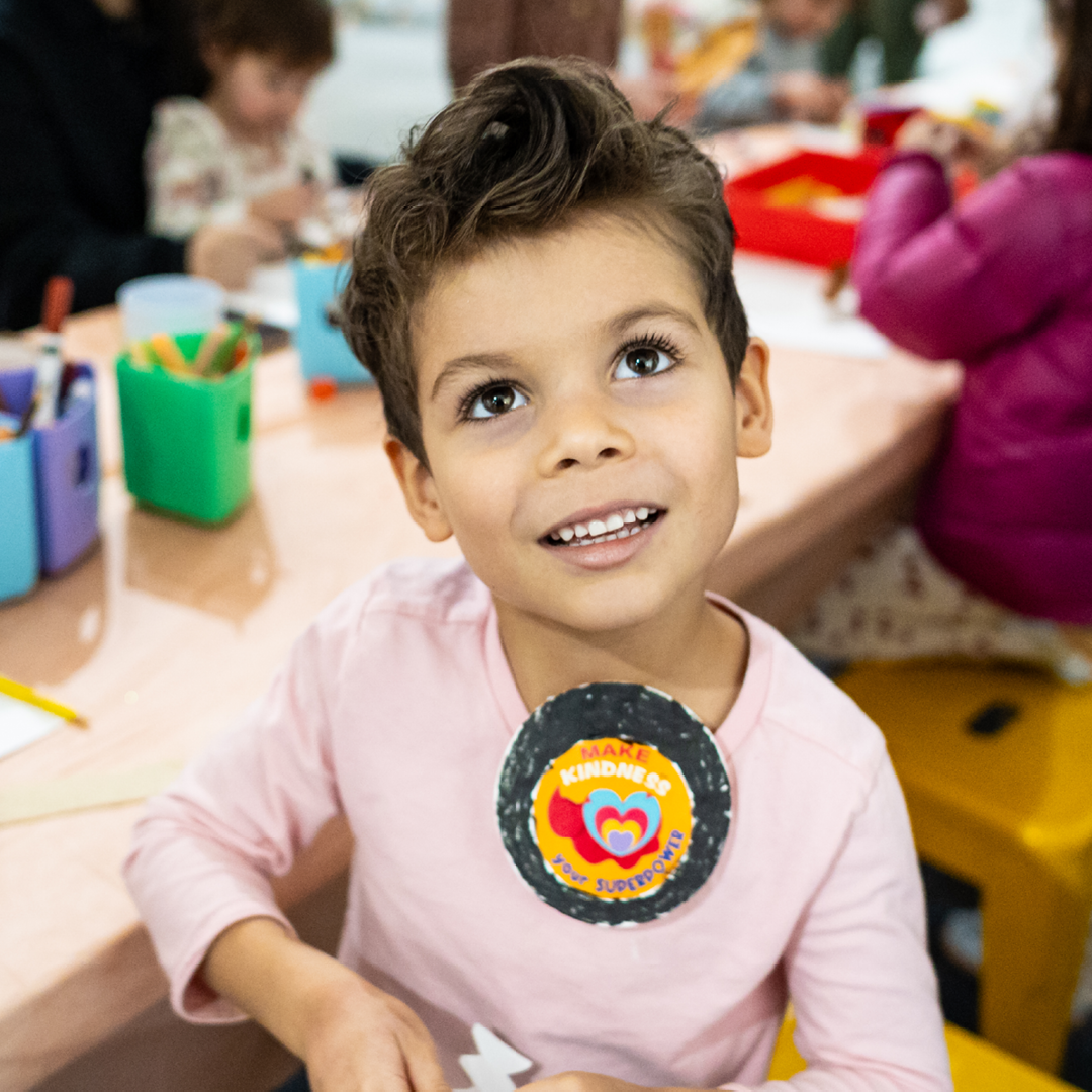 Child happily wears a badge they made
