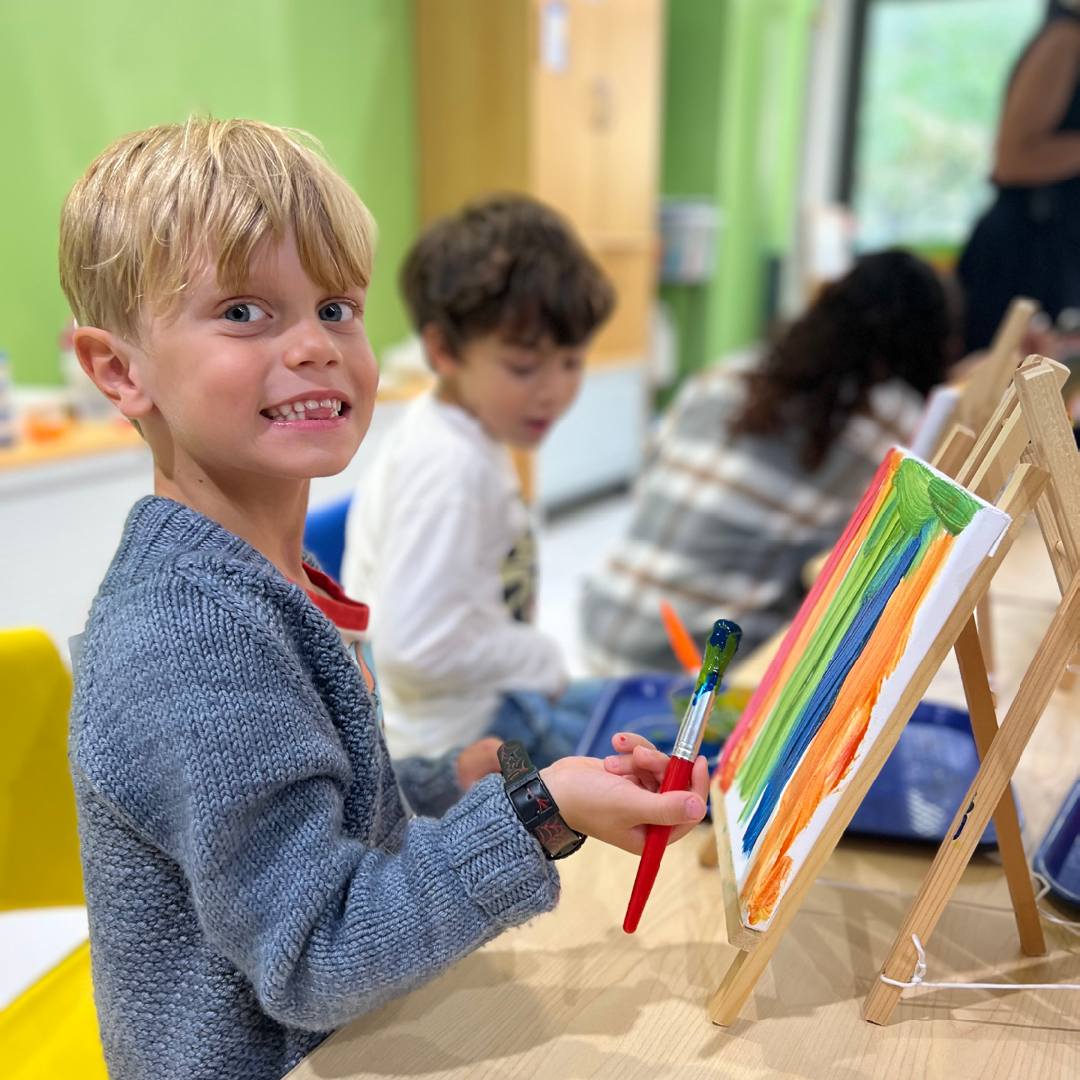Child paints a colorful painting on a canvas