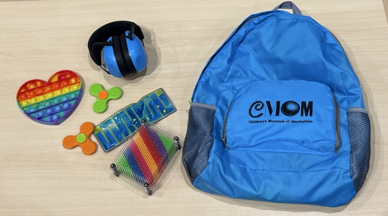 A photo of a sensory kit--headphones and fidget toys in a backpack