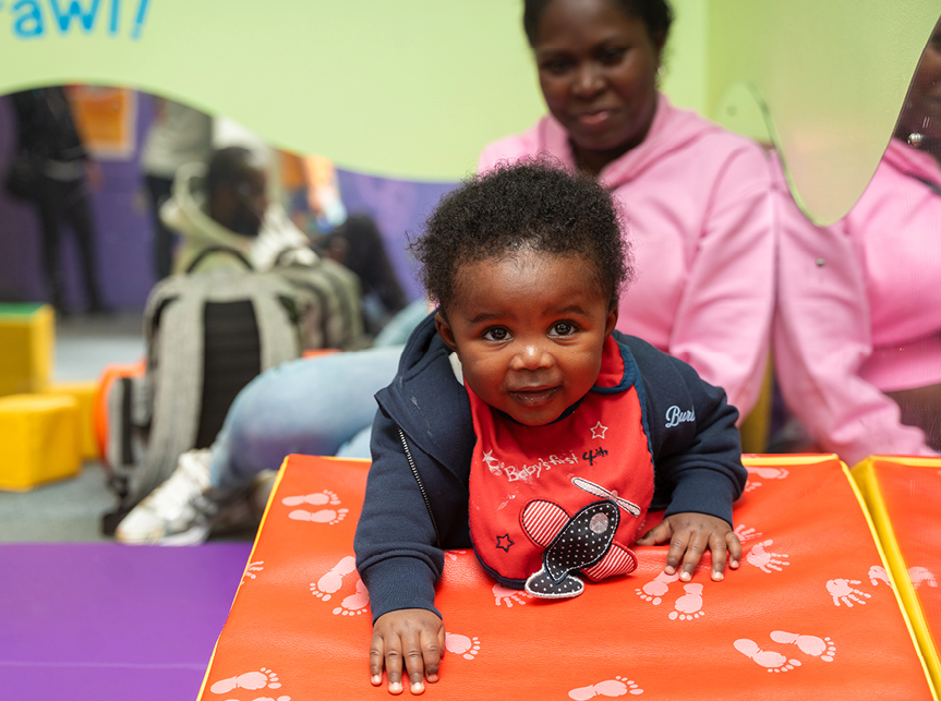 A young infant crawls towards the camera.